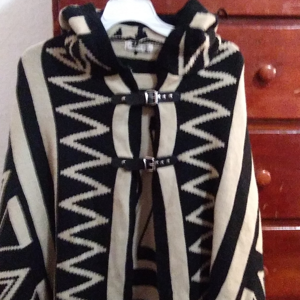 Hooded poncho. Find with leather buckle closures.